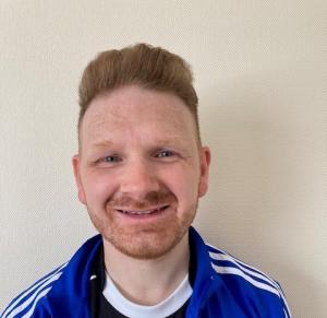 Stephen Crabbe - man with ginger hair and beard wearing blue top