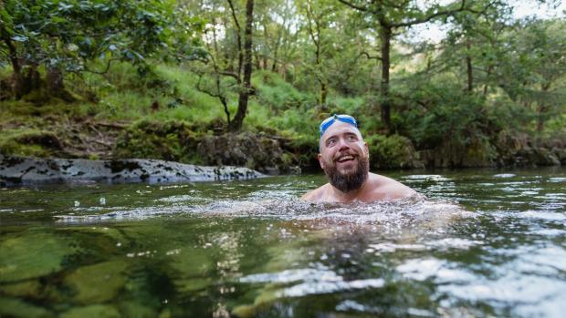 Man wild swimming in a river