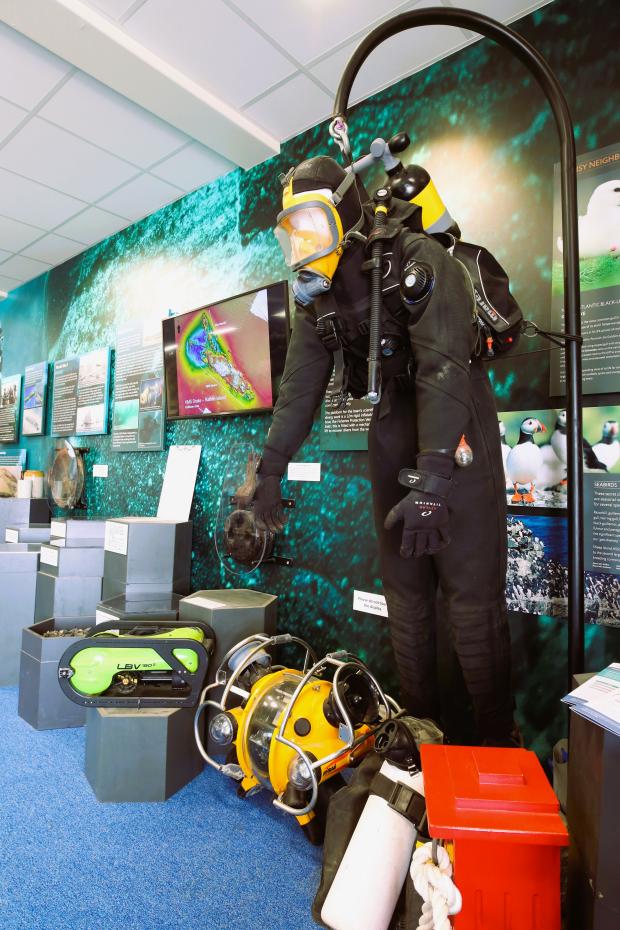 A photograph of a modern SCUBA diver suit on display.